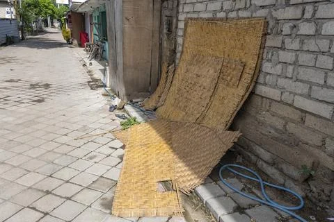 A wickerwork leaning against a brick wall at the side of the road Stock-Fotos