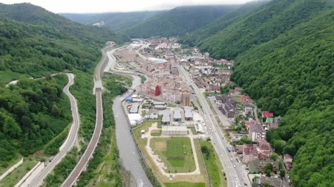 Wide aerial angle over hillside town and river route Stock Footage 321036646