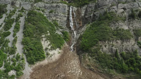 Wide aerial drone pull back from Bridal Veil Waterfall reveals avalanche damage Stock Footage 248175267