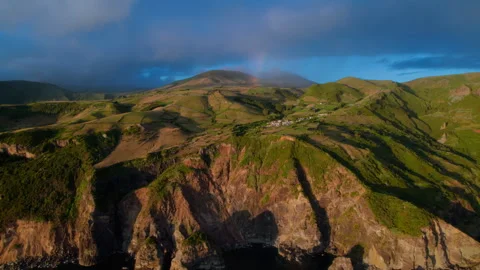 Wide aerial drone view of a dramatic volcanic coastline at golden hour 動画素材 335711386