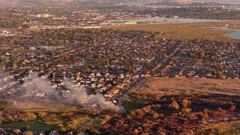 Wide Aerial of a Grass Fire Burn Scar Reaching a Neighborhood at Golden Hour 動画素材 341840388
