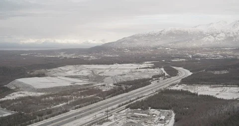 Wide aerial helicopter flyover of trees on a winter hillside, snowy white, push Stock Footage 108321553