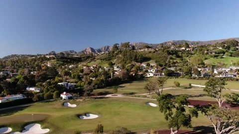 Wide aerial of Montecito golf course and luxury homes with mountain backdrop Stock Footage 211190751