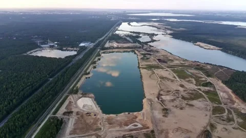 Wide aerial panoramic view of sand quarry with artificial lake and city horizon Stock Footage 344757405