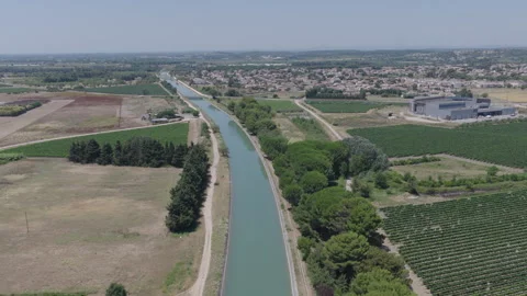 Wide aerial perspective of a long curving canal bordered by vineyards Stock Footage 337991441