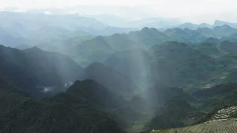 Wide aerial pull-out of rain-fed waterfalls and terraced fields in Mộc Châu Stock Footage 325273981