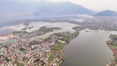 Wide aerial pullback revealing Srinagar city, Dal Lake, and Himalayan mountains. Видео 333792963