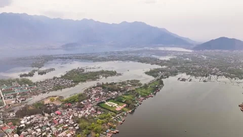 Wide aerial pullback revealing Srinagar city, Dal Lake, and Himalayan mountains. Видео 333792967