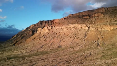 Wide aerial of red desert cliffs in Hurricane Utah at sunset with stormy skies Stock Footage 236589032