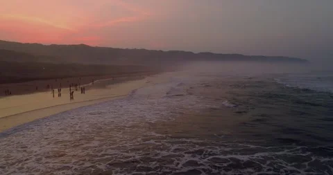 Wide Aerial Shot of Waves Rolling Across Coastal Shoreline Vídeos de archivo 332149372