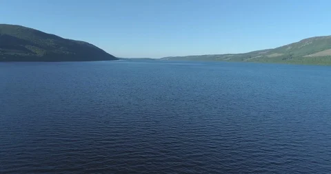 Wide aerial tracking back over Loch Ness to reveal Urquhart Castle ruins on the Vídeos de archivo 112001604