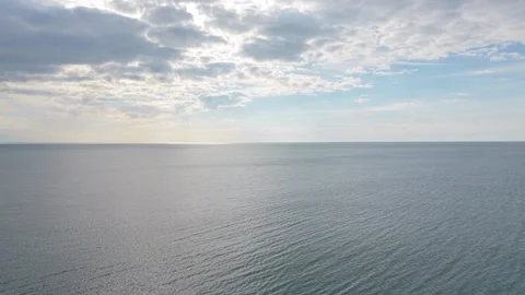 Wide Aerial View Across Open Sea With Bright Cloudy Weather Conditions Stock Footage 334919076