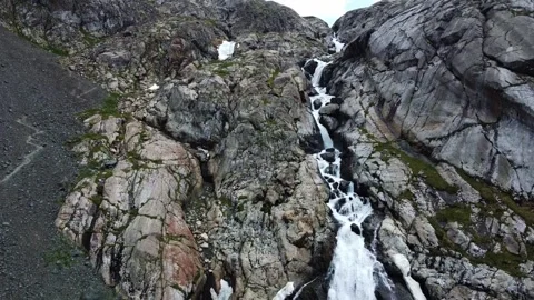 Wide aerial view of multi-tiered mountain waterfall and hiking trail on cliff Stock Footage 334625210