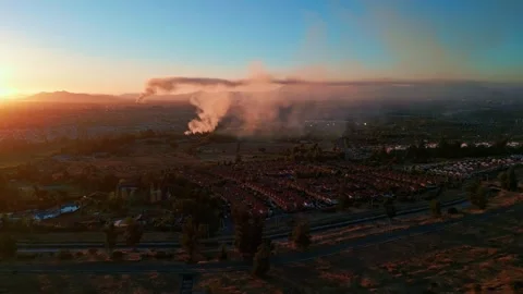 Wide aerial view over dense residential suburb at sunset with dramatic smoke Stock Footage 336267340