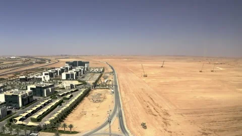 Wide aerial view of a road separating offices and a work site 库存影片 346429630