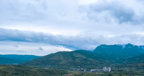 Wide Aerial View of Rolling Mountain Ranges Under a Cloudy Overcast Sky Stock Footage 342090881