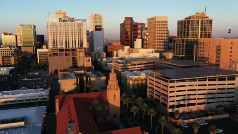 Wide aerial view of the sun setting over downtown Phoenix, Arizona with a Vídeo Stock 234159550