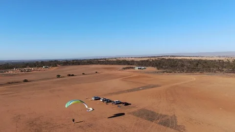Wide aerial view tracking powered paragliding takeoff and flying in the Stock-Footage 118423573