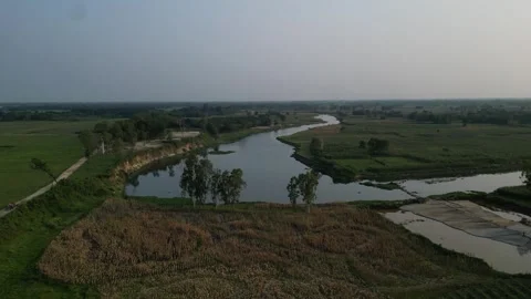 Wide aerial view of winding river flowing through green rural farmland Stock Footage 342303080