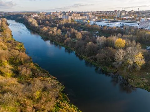 A wide and calm river flows through a large city, past a park and a forest. A Фото