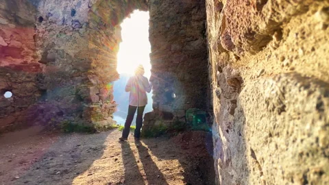 Wide angle 4K video shot of warm clothed tourist woman enjoying the sunset sun l Stock-Footage 248900616