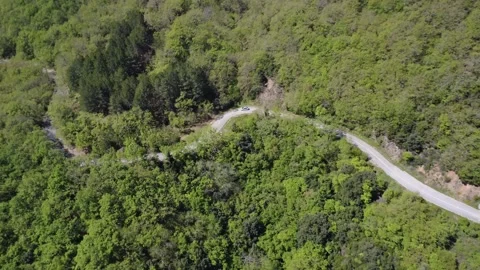 Wide angle aerial shot above dangerous mountain road inside green forest Stock Footage 337046308