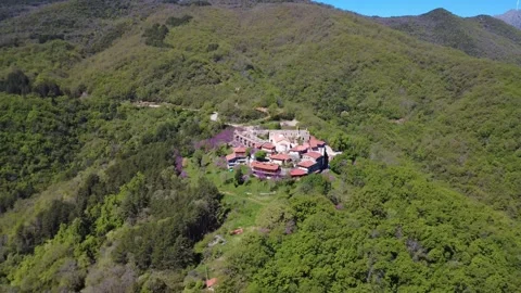 Wide angle aerial shot of isolated mountain village on forested hillside Stock Footage 337046791