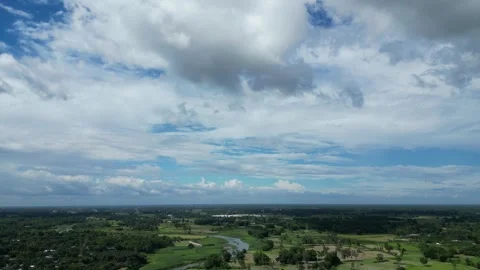 Wide angle aerial view of blue sky with cumulus clouds over green rural Stock Footage 341936644