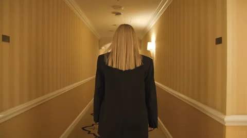 Wide angle back view of formally dressed female girl in Luxury room corridor Stock Footage 241290263