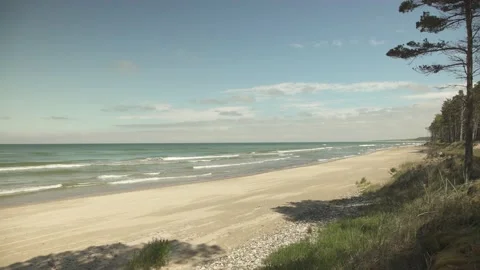 Wide angle beach scene with white sand and small waves in sunny summer day Video stock 159981560