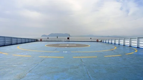 Wide angle of a blue heliport helipad in the middle of the sea Stock Footage 105678393