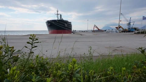 Wide angle of cargo ship docked at empty concrete port with cranes Stock Footage 337458159