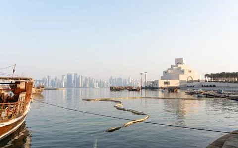Wide-angle Doha harbor view with marine containment boom and Museum of Isla.. Stock Photos