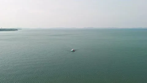Wide angle drone orbit approaching isolated sunken vessel in tranquil misty bay Stock Footage 320429403