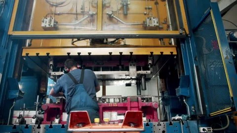 Wide angle of a factory worker fixing a big hydraulic car part shaping Stock Footage 255215579