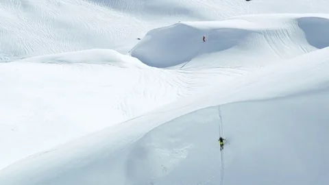 Wide angle of freeride skier shredding big mountain on sunny day in Alaska Stock Footage 129100722