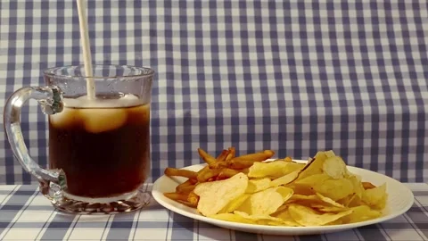 Wide angle front view of yellow golden potato chips and cripsy french fries.. 動画素材 318127658