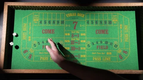 Wide angle hand rolls dice on craps table slow motion Stock Footage 153952785