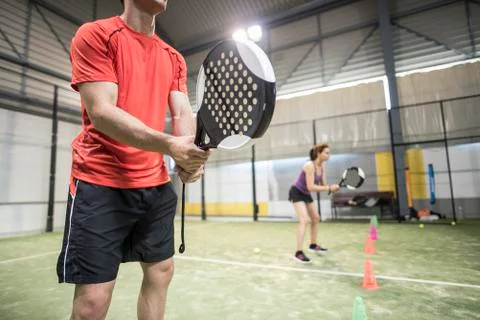 Wide angle image of couple training in paddle tennis class behind cones Stock Photos