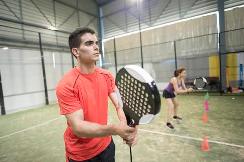 Wide angle image of couple training in paddle tennis class behind cones Stock Photos