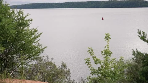 Wide Angle Lake Shore View with Lush Greenery and Calm Water on Overcast Day Stock Footage 341428119