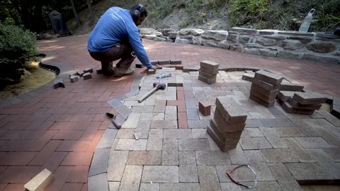 Wide angle lens shows the custom made stone wall and brick paving artisan in Stock Footage 80496955