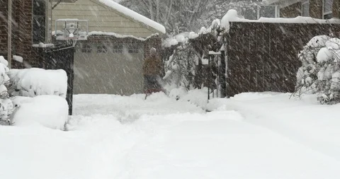 Wide-angle of man operating snow blower, Salt Lake City, Utah. Video stock 124332924