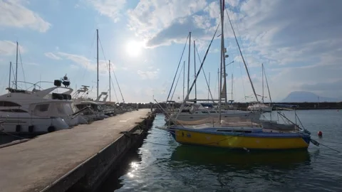 Wide angle marina scene with sailboat sunset and calm cloudy sea Stock Footage 337048848