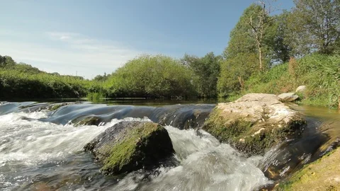 Wide angle pan shot of A small creek with black stones Stock Footage 86770581