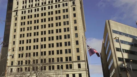 Wide angle pan of small midwest downtown revealing tattered diversity flag Stock Footage 147900979