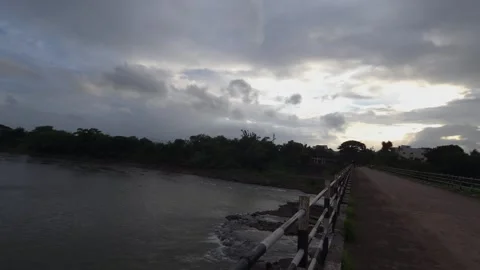 Wide angle perspective from a concrete bridge capturing a slow-moving river unde Stock-Footage 342477331