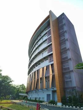 Wide angle perspective of a modern curved building and driveway. Stock Photos