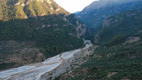 Wide angle push in aerial view of a river emerging from a mountain gorge Stock Footage 343962055