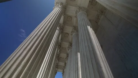 Wide angle pushing through very large towering columns in front of US Supreme Stock Footage 211786964